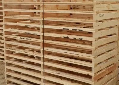 close up of large stack of 3 stringer wooden pallets