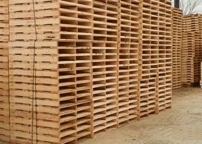 large stacks of two way wooden pallets stacked outdoors